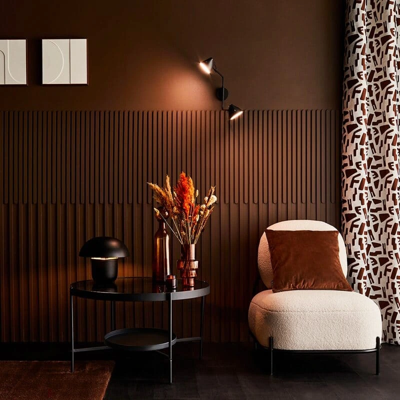 Salon moderne aux murs marron chocolat en color drenching, mobilier contemporain et éclairage tamisé, tendance peinture 2026 pour un intérieur chaleureux dans la Loire.